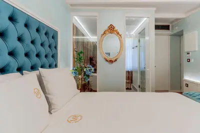 a bedroom with a large white bed with a blue headboard at Madame Hortense Boutique Ηotel in Chania Town