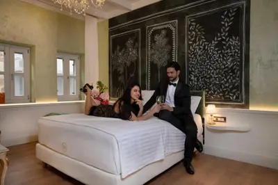 a man and a woman sitting on a bed at Madame Hortense Boutique Ηotel in Chania Town