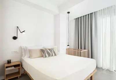 a white bedroom with a large bed and a window at Villa Melista in Kounoupidhianá