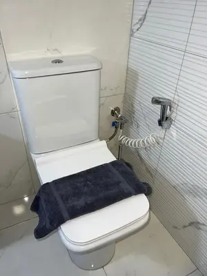 a bathroom with a toilet with a blue towel on it at Holiday Base in Stalos