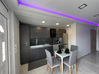 a kitchen with a table and chairs and a purple lighting at Holiday Base in Stalos