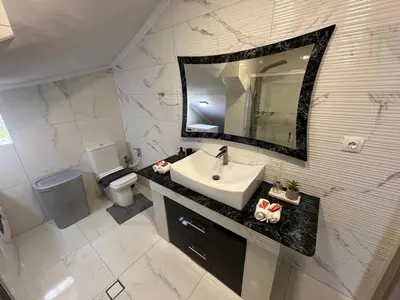 a bathroom with a sink and a mirror and a toilet at Holiday Base in Stalos
