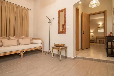 a living room with a couch and a table at Το Ρόδι Voutas Cottage house in Palaiochóra