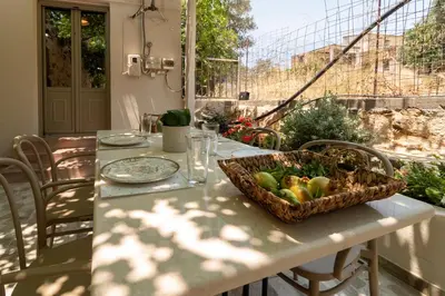 a table with a basket of fruit on top of it at Το Ρόδι Voutas Cottage house in Palaiochóra