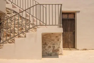 a set of stairs with a door in front of a building at Το Ρόδι Voutas Cottage house in Palaiochóra