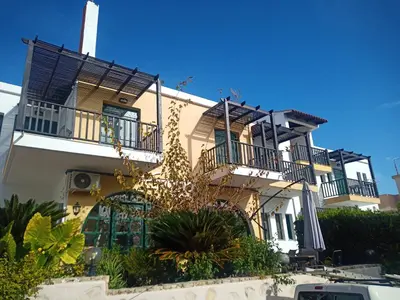 a house with balconies and a car parked in front of it at Elysian Garden in Kalyves