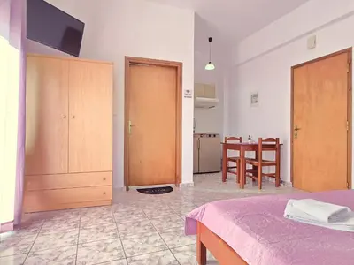 a room with a bed and a kitchen with a table at Inna Rooms in Fournádhos