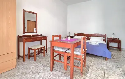 a bedroom with a table and a bed and a mirror at Inna Rooms in Fournádhos