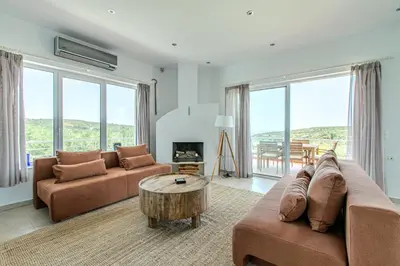a living room with two couches and a table at Villa Xamadochori in Xamoudhokhórion