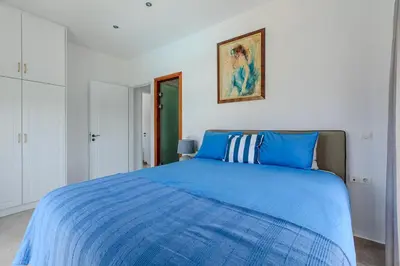 a bedroom with a blue bed with a blue comforter at Villa Xamadochori in Xamoudhokhórion