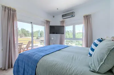 a bedroom with a bed and a large window at Villa Xamadochori in Xamoudhokhórion