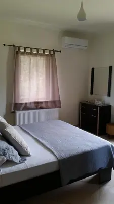 a bedroom with a large bed with a window at Villa Ikaros in Kalamitsi Amygdali