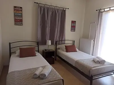 two beds sitting in a room with a window at Villa Ikaros in Kalamitsi Amygdali