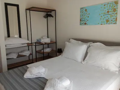 a bedroom with a bed with white sheets and pillows at Golden Orb in Chania Town
