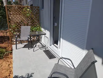 a porch with a bench and a table and a fence at Golden Orb in Chania Town