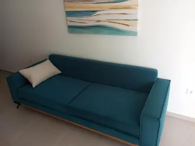 a blue couch in a room with a painting at Silver Orb in Chania Town