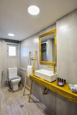 a bathroom with a sink and a toilet and a mirror at Kumka seafront suite in Chania Town