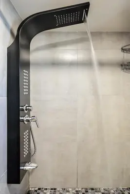 a shower with a shower head in a bathroom at Kumka seafront suite in Chania Town