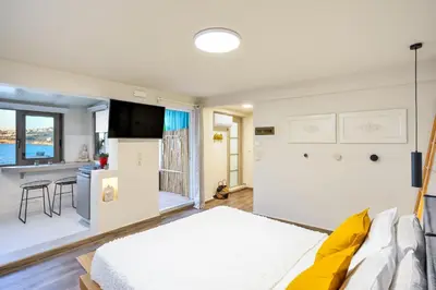 a bedroom with a bed and a kitchen with a sink at Kumka seafront suite in Chania Town