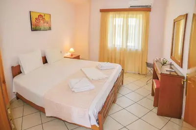 a bedroom with a large white bed in a room at Mairy's Apts Paleochora Mimagia in Palaiochóra