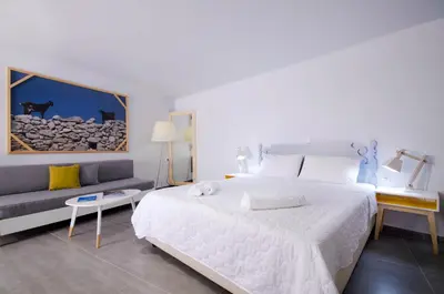 a bedroom with a large white bed and a couch at Kallimento in Kissamos