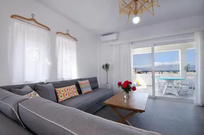a living room with a gray couch and a table at Kallimento in Kissamos
