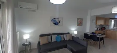 a living room with a couch and a kitchen at Seaside apartment in Chania in Chania Town
