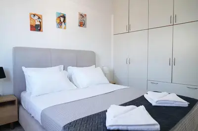 a white bedroom with a large bed with white cabinets at Seaside apartment in Chania in Chania Town