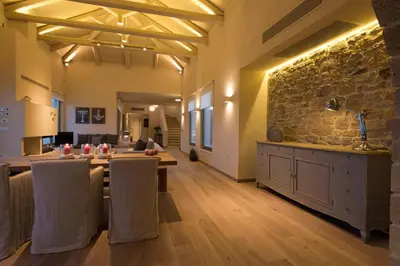 a dining room with a table and a stone wall at Villa Ianira in Kolymvari