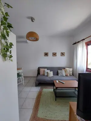 a living room with a couch and a table at Stavros Oak Tree House in Vasilópoulon