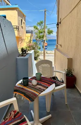a table and chairs on a patio with a view of the ocean at BONATSA Rooms 2 in Palaiochóra