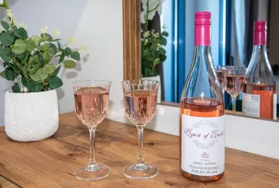 a bottle of wine and two glasses on a table at Blue Balcony - Boutique Beachfront Suite with Private Parking Spot in Chania Town