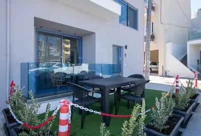 a black table and chairs on a patio with plants at Blue Balcony - Boutique Beachfront Suite with Private Parking Spot in Chania Town