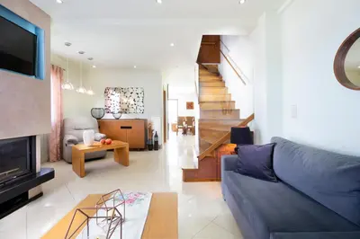 a living room with a couch and a tv and a staircase at Loft Apartment in Chania Town