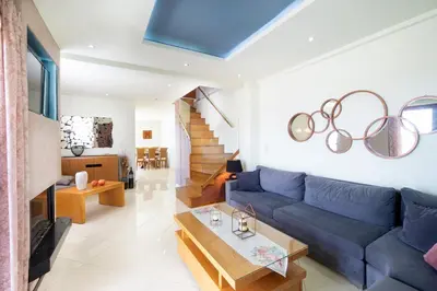 a living room with a blue couch and a table at Loft Apartment in Chania Town