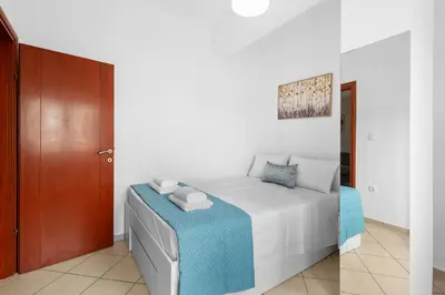 a bedroom with a bed and a wooden door at Marika's Apartment in Chania in Chania Town