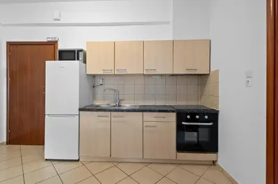 a kitchen with wooden cabinets and a white refrigerator at Marika's Apartment in Chania in Chania Town
