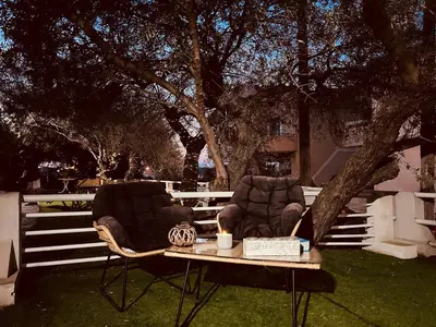 two chairs and a table with a candle on the grass at Elias Nest in Galatás