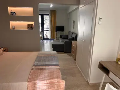 a bedroom with a bed and a living room at Elias Nest in Galatás
