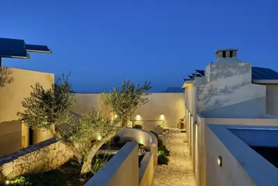 a house with a courtyard at night at Evans Villas in Kissamos