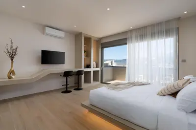 a bedroom with a large bed and a flat screen tv at Selected Suites in Chania Town