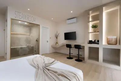 a bedroom with a bed and a tv in a room at Selected Suites in Chania Town