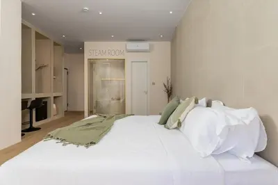 a white bed in a room with a sign on the wall at Selected Suites in Chania Town