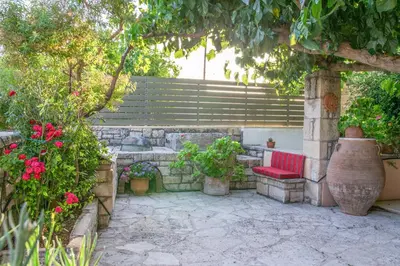 a patio with a red bench and some flowers at Villa Rouga by Andrian Villas in Kalamítsion Alexándrou