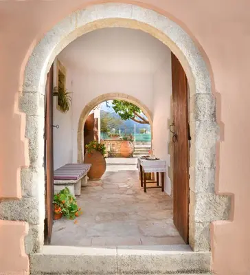 an archway leading to a patio with benches at Villa Rouga by Andrian Villas in Kalamítsion Alexándrou