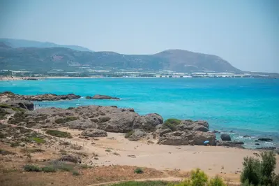 a beach with rocks and the blue water at Elia Suites in Falasarna