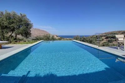 a blue swimming pool with a view of the ocean at Villa Simera, with pool & great view in Fournádhos