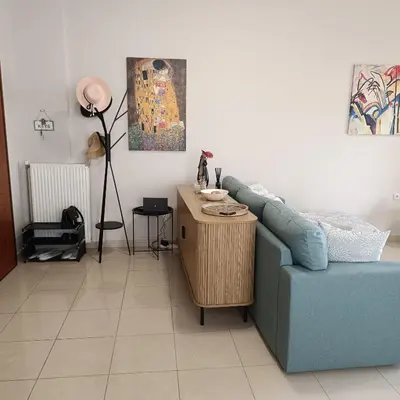 a living room with a blue couch and a table at Del's Apartment in Chania Town