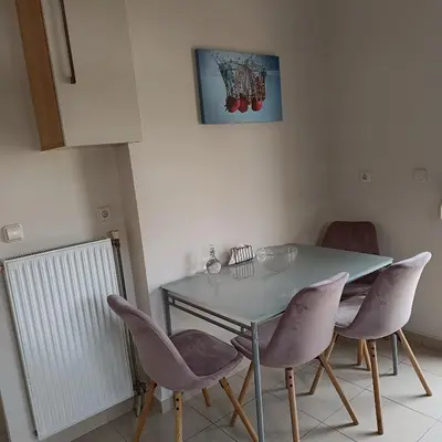 a dining room with a table and four chairs at Del's Apartment in Chania Town