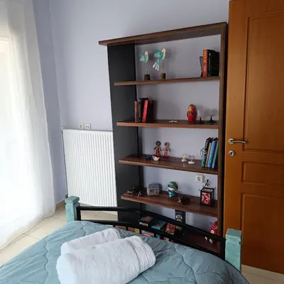 a bedroom with a bed and a book shelf at Del's Apartment in Chania Town